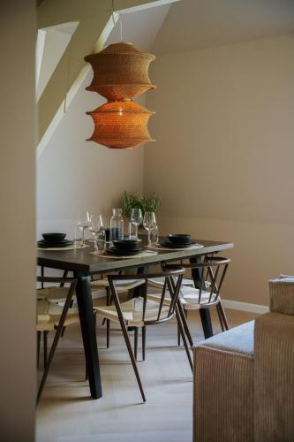a dining room with a table with glasses and a chandelier at Naest - Authentic Escapes Grand House in Nijmegen