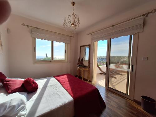 a bedroom with a bed and a large window at ROSE VILLA - 3 BED POOL in Episkopi Limassol