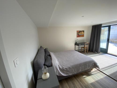 a bedroom with a bed and a table and a desk at La Grande Mimi in Jard-sur-Mer