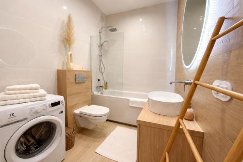 a bathroom with a washing machine and a toilet at BONA Apartment in Świecie