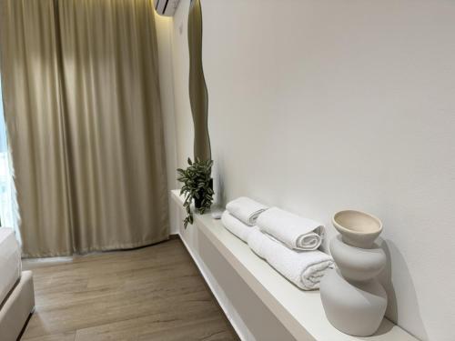 a white bathroom with white towels on a shelf at La Dimora Azzurra in Vlorë