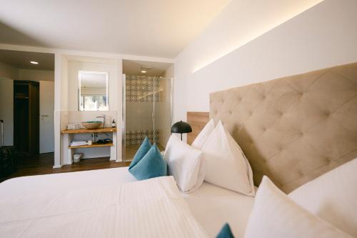 ein Schlafzimmer mit einem großen weißen Bett und blauen Kissen in der Unterkunft Hotel Weiß in Munderfing