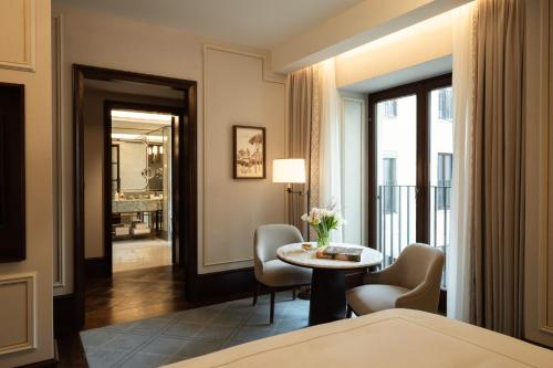 a hotel room with a bed and a table and chairs at Corinthia Rome in Rome