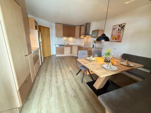 a kitchen and dining room with a wooden table at Ferienwohnung Leitacker im Kaiserwinkl in Rettenschöss