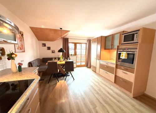 a kitchen and living room with a table and a couch at Ferienwohnung Leitacker im Kaiserwinkl in Rettenschöss