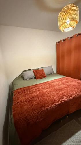 a bedroom with a bed with a wooden headboard at Le Green d'Apigné in Le Rheu