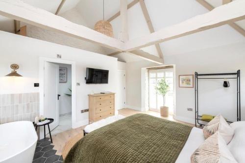 a bedroom with a large bed and a tv at The Foaling Box at Lanhill in Oakhill