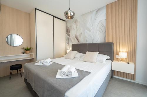 a bedroom with a large bed with towels on it at Apartments Olive Gardens 2 in Novalja