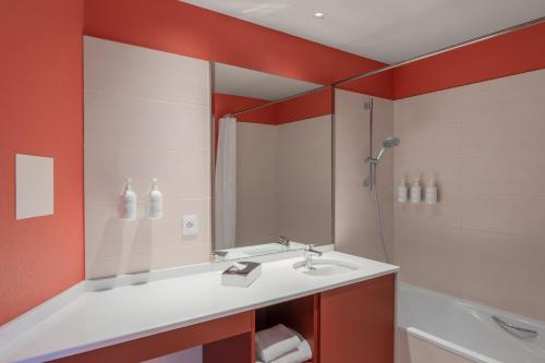 a bathroom with a sink and a shower at Spark by Hilton Lyon Eurexpo in Genas