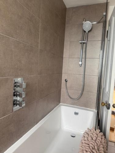 a bathroom with a shower with a white tub at Murrayfield Gem in Edinburgh
