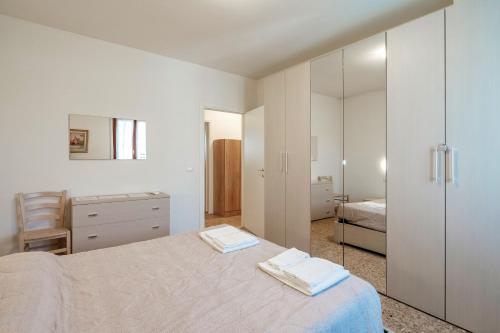 a white bedroom with a bed and a mirror at Villa Ferri in Peschiera del Garda