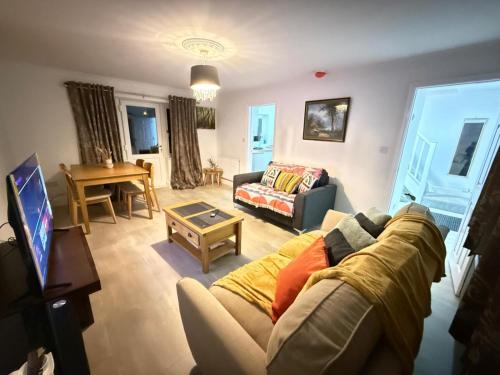 a living room with a couch and a table at Comfy, king bed families & Contractors welcome in St. Ives