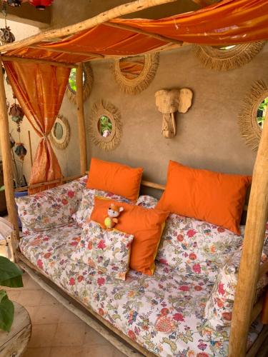 a bedroom with a bed with orange pillows at Kasbah Didi in Lalla Takerkoust