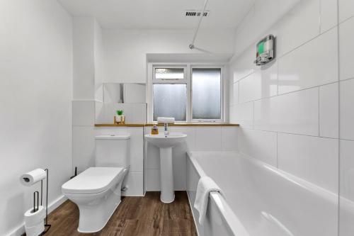 a white bathroom with a toilet and a sink at 4 Bedroom Fully Furnished House - Longer Stay Offers - Contractor Digs - NEW in Crawley