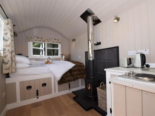 a bedroom with a bed and a stove in it at 1 Bed in Hereford oc-78641 in Callow