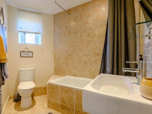 a bathroom with a toilet and a tub and a sink at 2 Bed in Crickhowell oc-90346 in Crickhowell