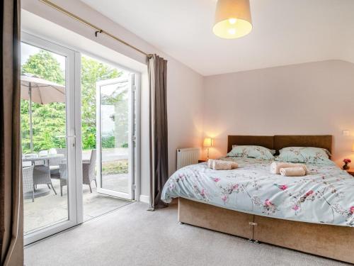 a bedroom with a bed and a sliding glass door at 2 Bed in Llangammarch Wells oc-bn059 in Garth