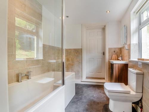 a bathroom with a tub and a toilet and a sink at 2 Bed in Llangammarch Wells oc-bn059 in Garth