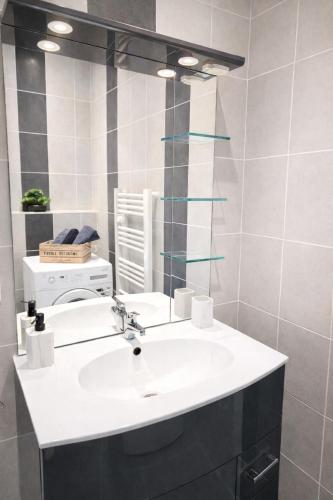 a bathroom with a white sink and a mirror at studio tout équipé, calme avec terrasse et parking in Audincourt