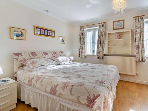 a bedroom with a large bed and two windows at 1 Bed in Abergavenny oc-52882 in Gilwern