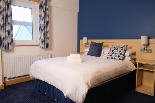 ein Schlafzimmer mit einem großen Bett und einer blauen Wand in der Unterkunft Feerick's Hotel in Rathowen