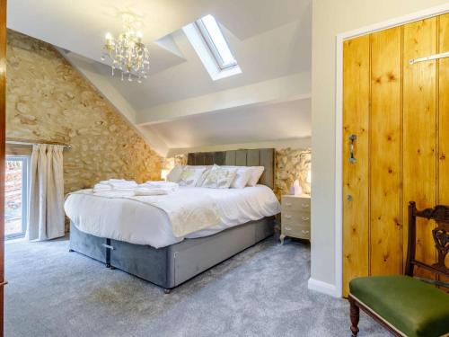 a bedroom with a large bed and a chandelier at 2 Bed in Matlock oc-83435 in Bonsall