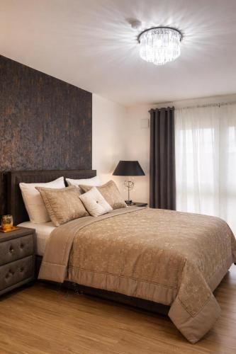 a bedroom with a large bed and a chandelier at Modern Royal Suite in Hirschaid