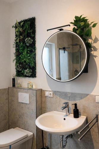 a bathroom with a sink and a mirror on the wall at Modern Royal Suite in Hirschaid