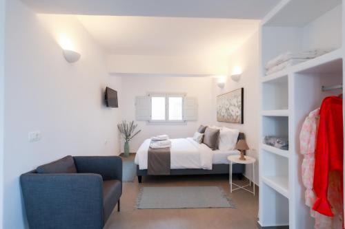a white bedroom with a bed and a couch at Stay Lux Suites in Karterados