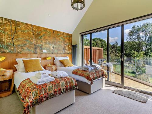 a bedroom with two beds and a large window at 4 Bed in Brecon oc-90596 in Bwlch
