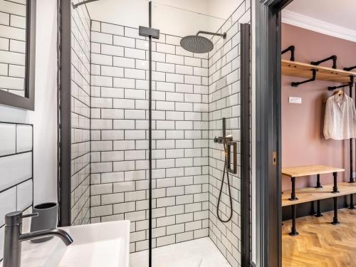 a glass shower in a bathroom with white subway tiles at 5 Bed in Bideford oc-78690 in Bideford