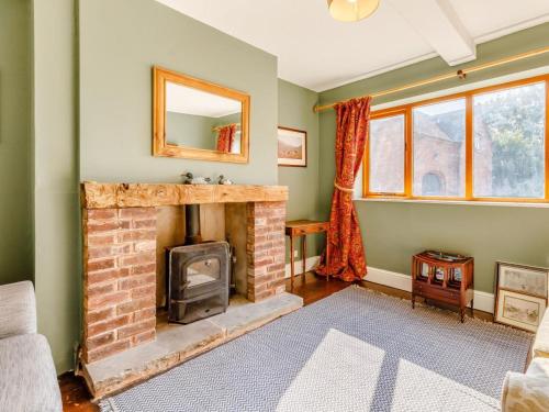 a living room with a brick fireplace and a mirror at 8 Bed in Rugeley oc-79321 in Abbots Bromley