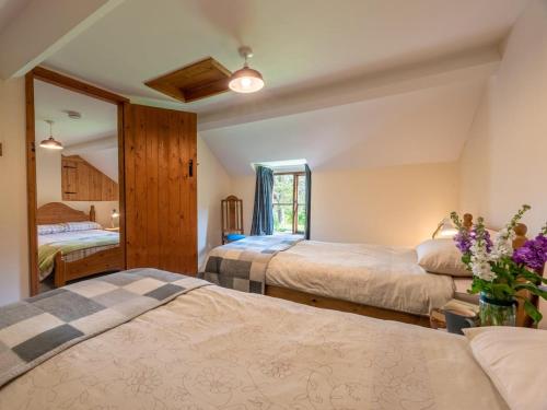 a bedroom with three beds and a mirror at 4 Bed in Hereford oc-86497 in Llanveynoe