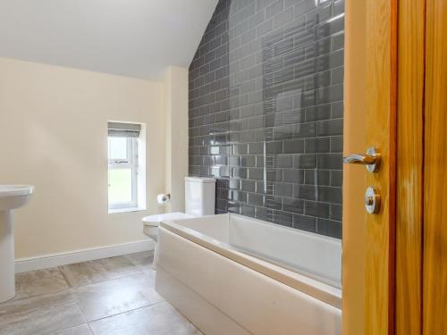 a bathroom with a bath tub and a toilet at 3 Bed in Matlock oc-78717 in Crich