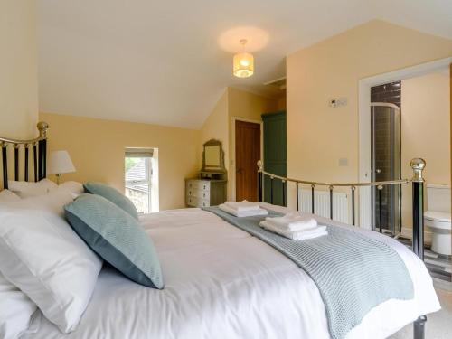 a bedroom with a large white bed with blue pillows at 3 Bed in Matlock oc-78717 in Crich