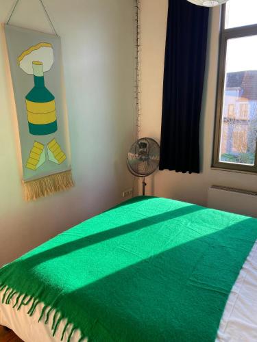 a bedroom with a green blanket on a bed at Vintage Lovers Antwerp in Antwerp