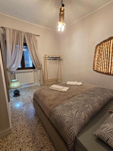 a bedroom with a bed and a lamp and a window at Casa Larissa in Rufina