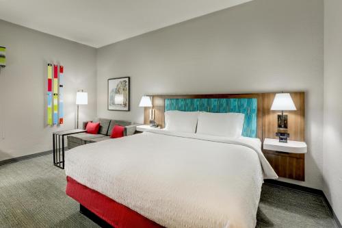 a hotel room with a large bed and a couch at Hampton Inn Beaufort in Beaufort