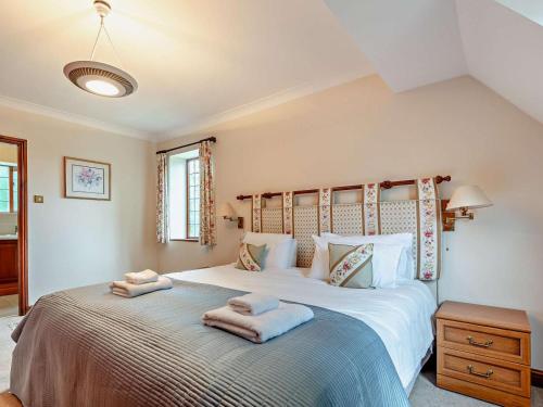 a bedroom with a large bed with towels on it at 5 Bed in Cheltenham oc-94643 in Lower Slaughter