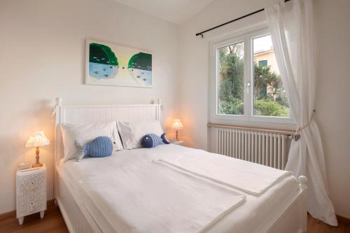 a white bed in a bedroom with a window at Il Nido in Brenzone sul Garda