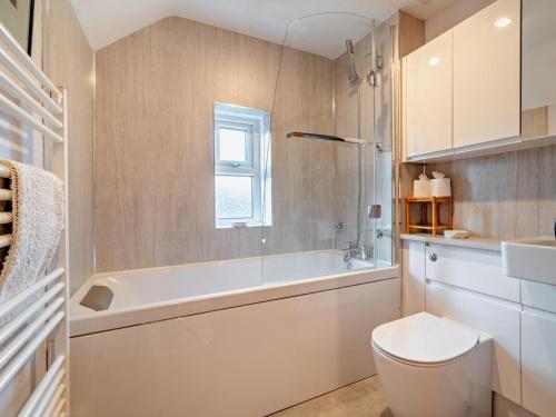a bathroom with a toilet and a tub and a sink at 3 Bed in Brecon oc-93947 in Llanywern