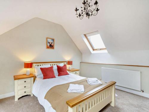 a bedroom with a large bed with red pillows at 4 Bed in Matlock oc-93830 in Crich