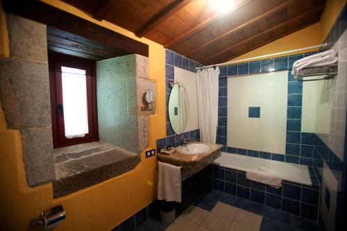 a bathroom with a sink and a tub and a mirror at Rectoral de Castillon in Pantón