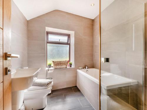 a bathroom with a tub and a toilet and a sink at 2 Bed in Hope Valley oc-94552 in Bradwell