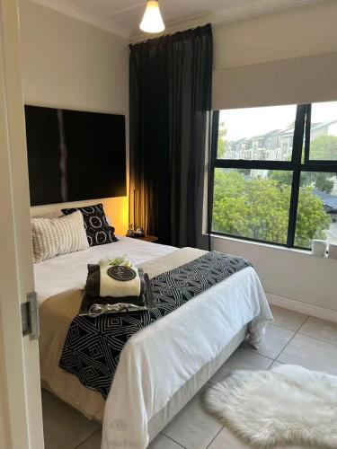 a bedroom with two beds and a large window at The Jade, Somerset West in Strand