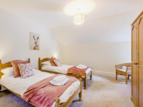 a bedroom with two beds and a chair at 6 Bed in Okehampton oc-estra in Okehampton