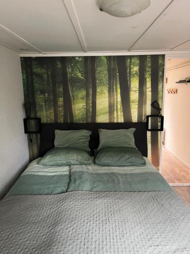 a bed in a bedroom with a large window at Hottub Forest Chalet op de Veluwe! in Putten