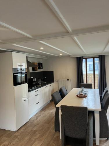 a kitchen and dining room with a table and chairs at Hottub Forest Chalet op de Veluwe! in Putten
