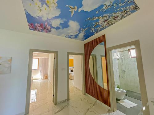 a bathroom with a ceiling with a painting of birds at Aqua kingstone apartments in Mombasa