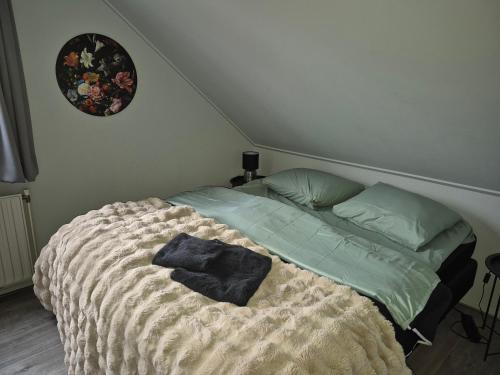 a bed with a comforter and pillows in a bedroom at Prachtige vakantievilla aan IJsselmeer Makkum in Makkum